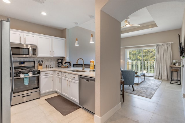 kitchen with appliances with stainless steel finishes, light tile patterned floors, sink, and decorative light fixtures