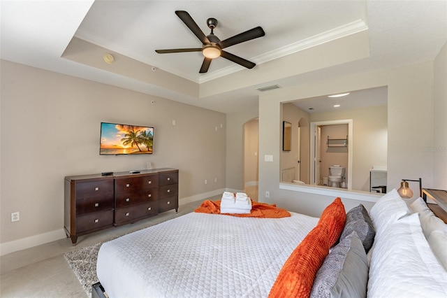 carpeted bedroom with ceiling fan and a tray ceiling