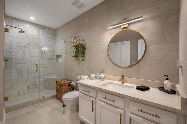 bathroom with toilet, vanity, and a shower with shower door