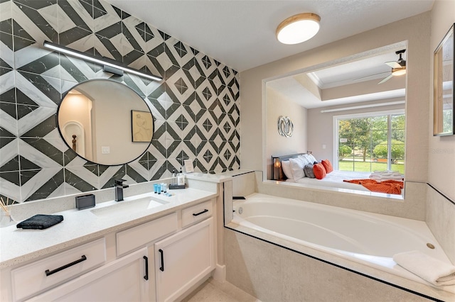 bathroom with ceiling fan, crown molding, tiled bath, and vanity