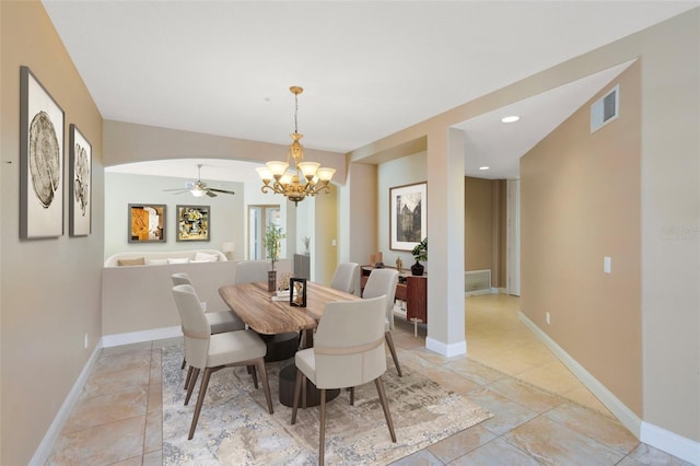 dining area featuring ceiling fan with notable chandelier