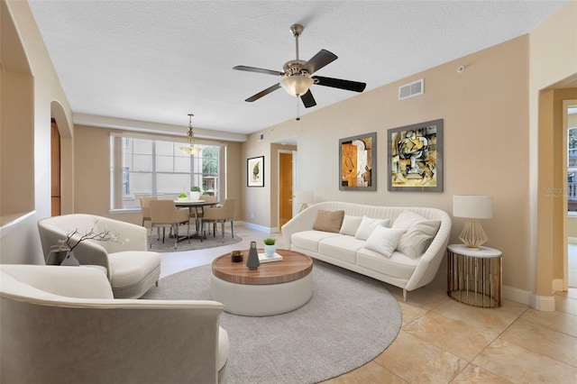 living room with ceiling fan and a textured ceiling