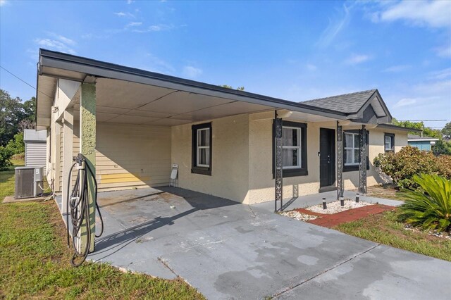 view of front of house with central air condition unit and a carport