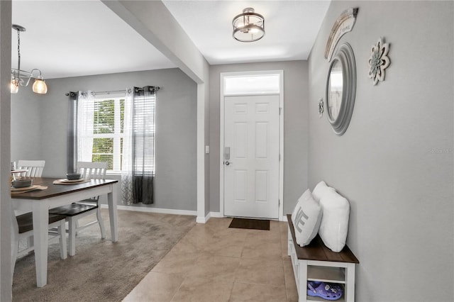 entrance foyer featuring an inviting chandelier and light tile patterned flooring