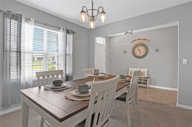 dining area with light carpet and a notable chandelier