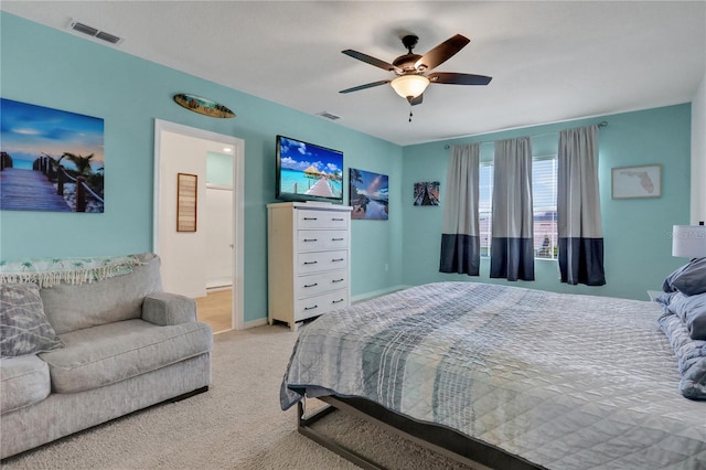 bedroom with ceiling fan, connected bathroom, and light carpet