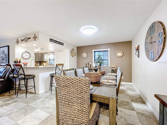 dining area with ceiling fan, plenty of natural light, and a textured ceiling