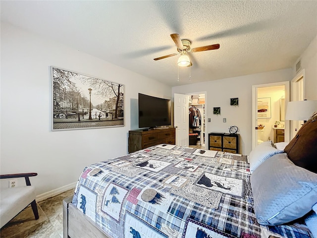 bedroom featuring ceiling fan, connected bathroom, a textured ceiling, a walk in closet, and a closet