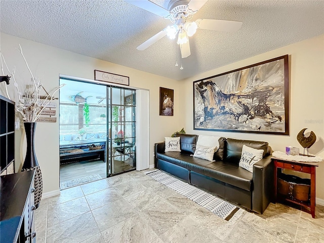 sitting room featuring ceiling fan and a textured ceiling