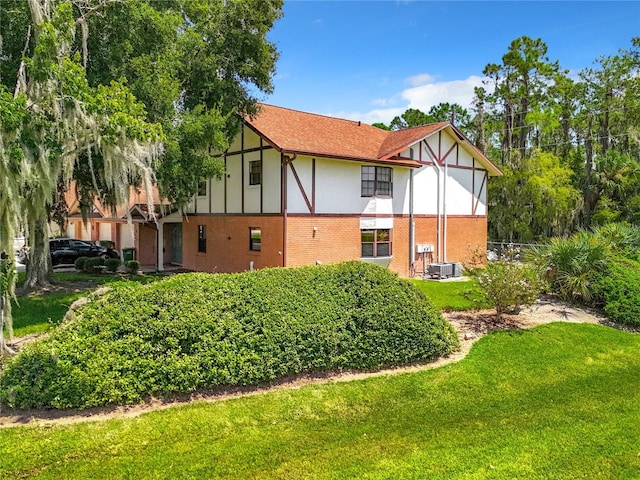 exterior space with central AC and a lawn