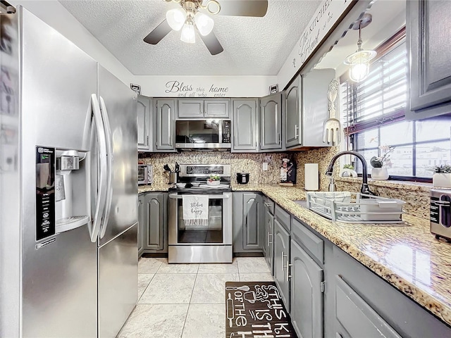 kitchen with sink, gray cabinets, stainless steel appliances, and hanging light fixtures