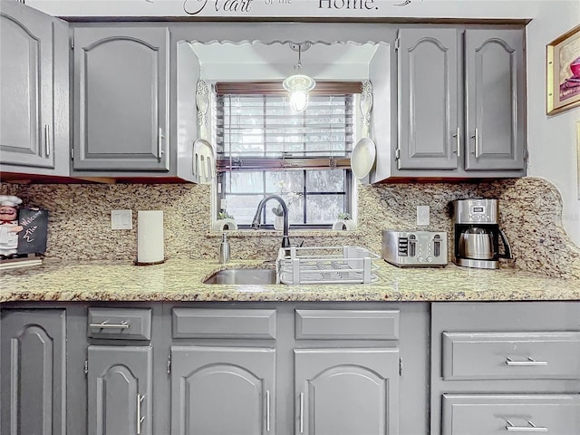 kitchen with gray cabinets, sink, and decorative backsplash