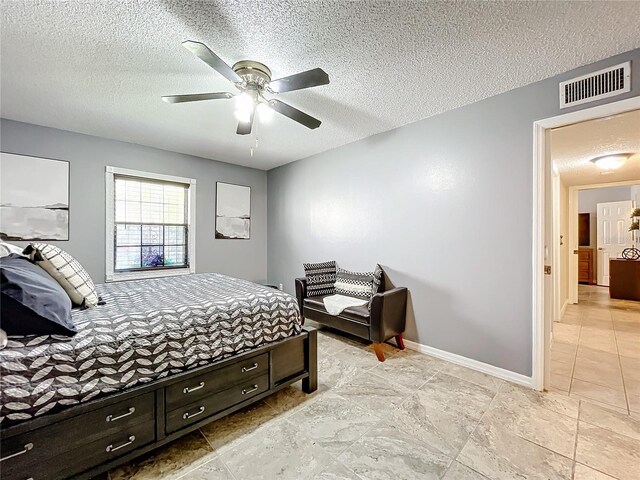 bedroom with ceiling fan and a textured ceiling