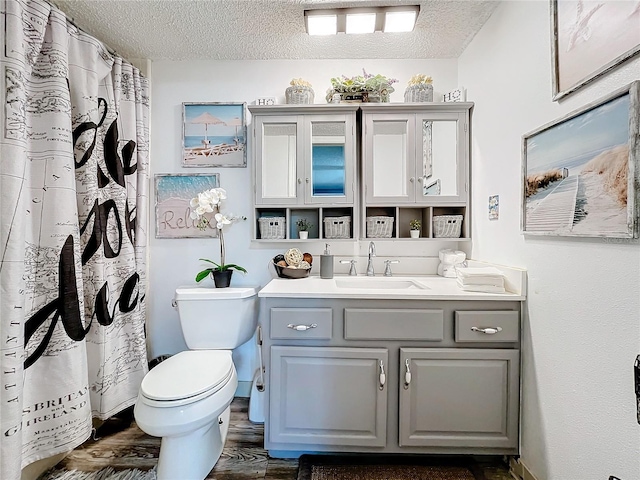 bathroom with vanity, hardwood / wood-style flooring, toilet, and a textured ceiling