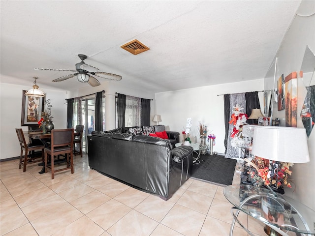 tiled living room with a textured ceiling and ceiling fan