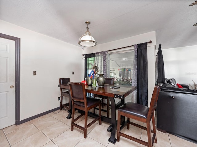 dining area featuring a textured ceiling and light tile patterned floors