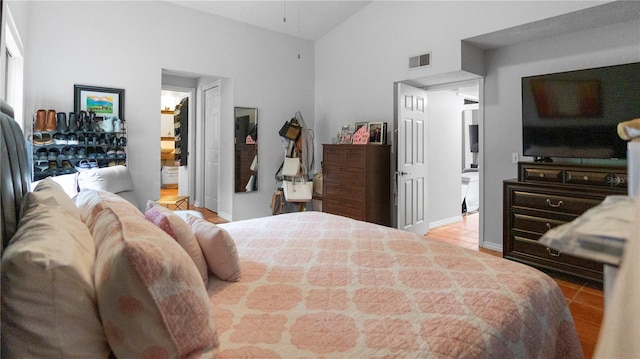 bedroom with lofted ceiling and light tile patterned flooring