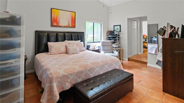 tiled bedroom featuring high vaulted ceiling