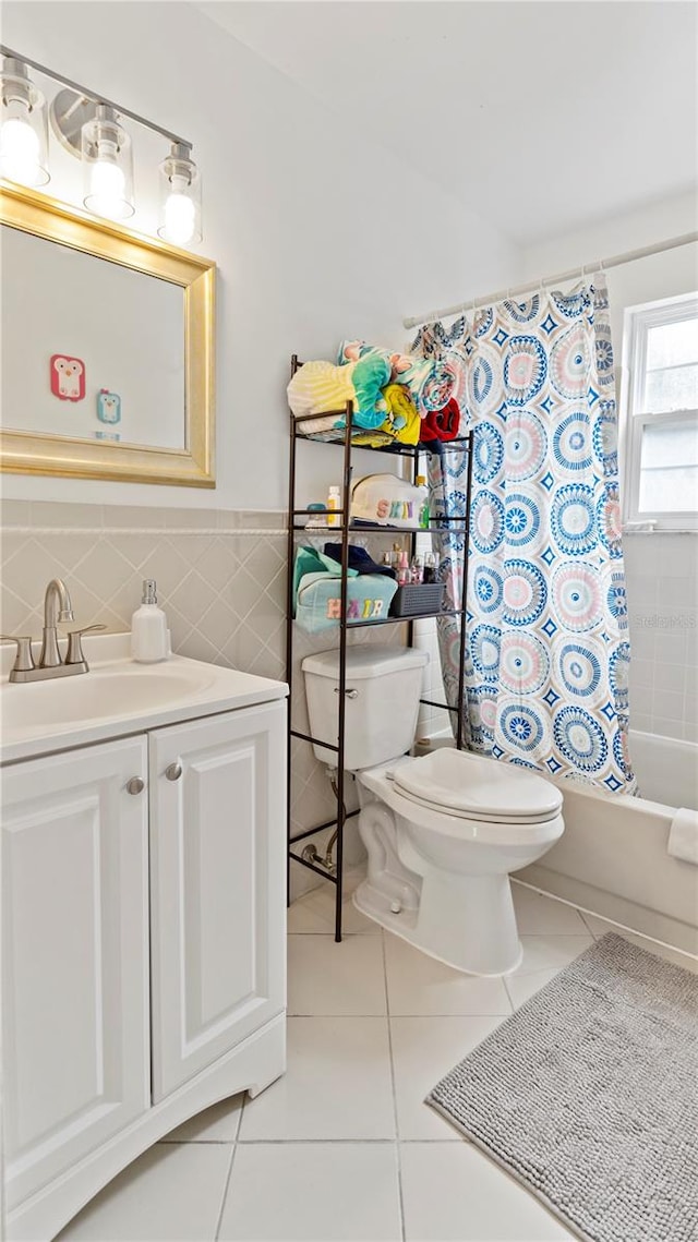 full bathroom with tile patterned flooring, shower / bathtub combination with curtain, toilet, tile walls, and vanity