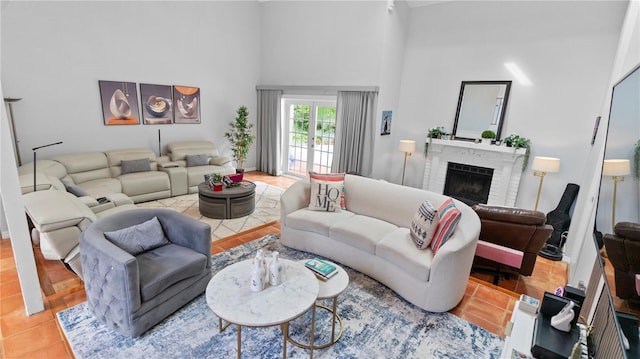 living room featuring a towering ceiling, light tile patterned floors, and a brick fireplace