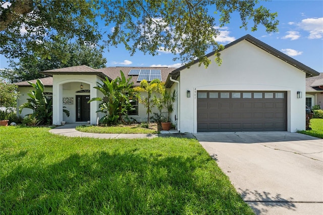 view of front of house with a garage, a front yard, and solar panels