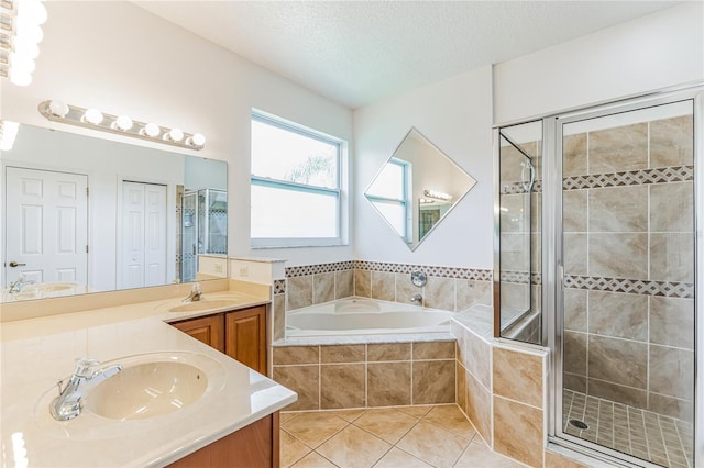 bathroom with double vanity, a textured ceiling, tile patterned floors, and independent shower and bath