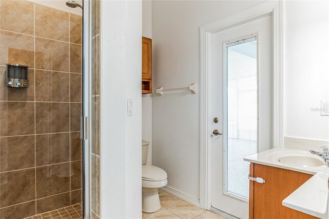 bathroom featuring tile patterned floors, vanity, a shower with door, and toilet