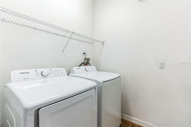 washroom with laundry area, baseboards, and washing machine and clothes dryer