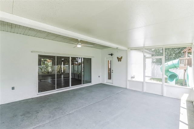 unfurnished sunroom with beamed ceiling and ceiling fan