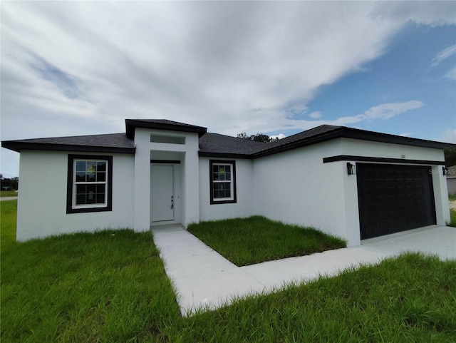 view of front of home with a front lawn and a garage