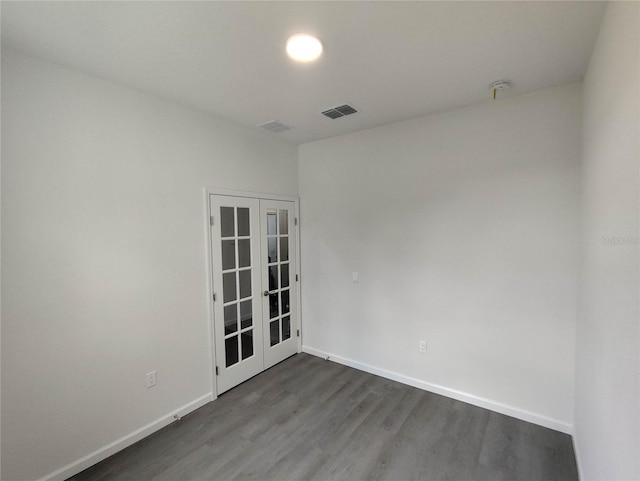 empty room featuring french doors and hardwood / wood-style floors