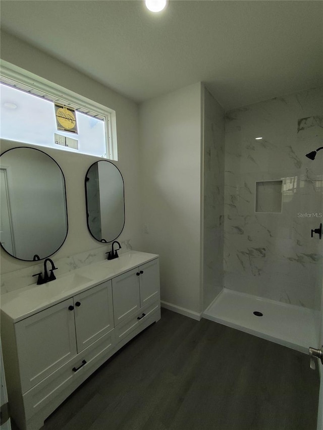 bathroom featuring a tile shower, hardwood / wood-style flooring, and vanity