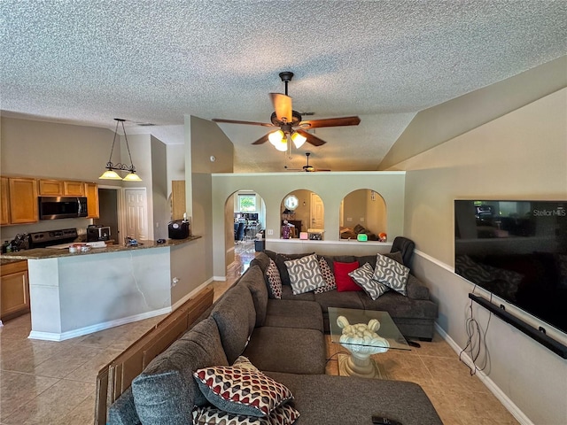 living area with lofted ceiling, a textured ceiling, light tile patterned flooring, and arched walkways