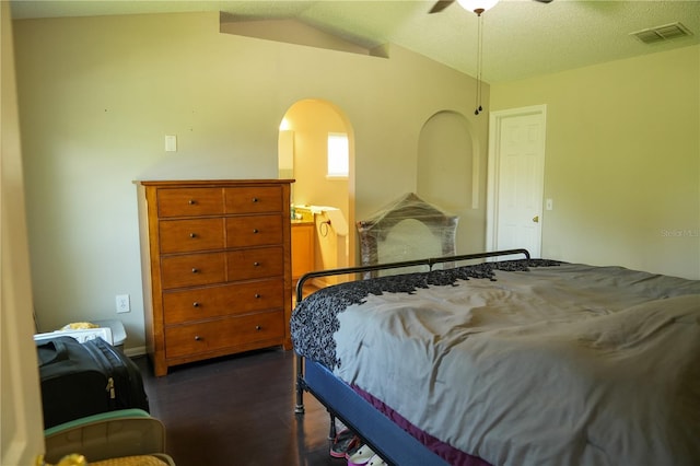 bedroom featuring ceiling fan, a textured ceiling, dark hardwood / wood-style flooring, and lofted ceiling