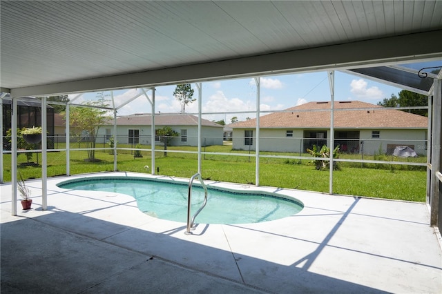 view of pool with a lawn, glass enclosure, and a patio area