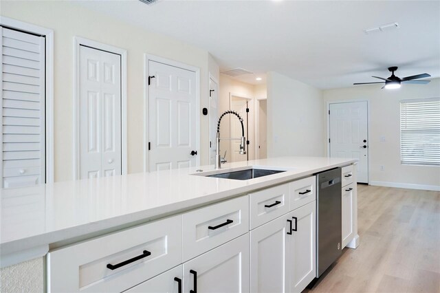 kitchen featuring white cabinets, ceiling fan, sink, stainless steel dishwasher, and light hardwood / wood-style flooring