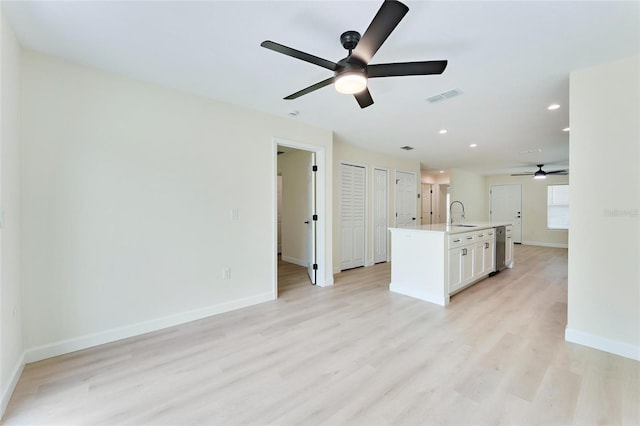 kitchen featuring white cabinetry, an island with sink, ceiling fan, and light hardwood / wood-style floors