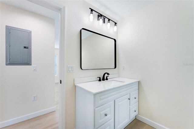 bathroom featuring vanity, hardwood / wood-style floors, and electric panel