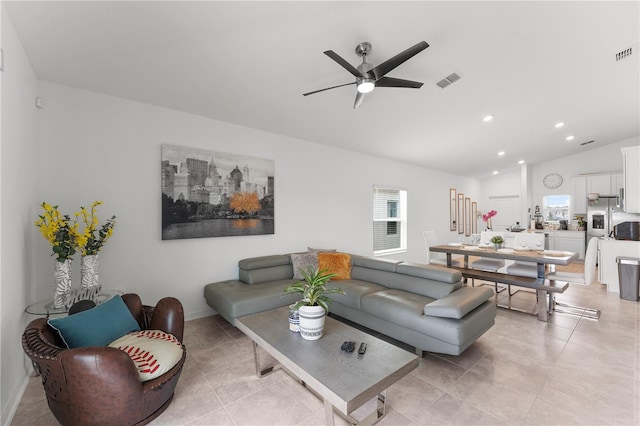 living room with ceiling fan, light tile patterned flooring, and vaulted ceiling