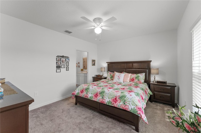 bedroom with ceiling fan, connected bathroom, and light colored carpet