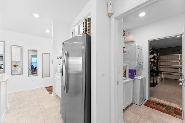 kitchen featuring washer / clothes dryer, light tile patterned floors, and stainless steel fridge