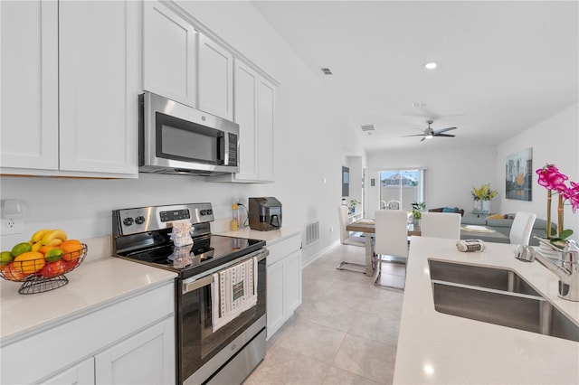 kitchen featuring ceiling fan, white cabinetry, light tile patterned floors, stainless steel appliances, and sink