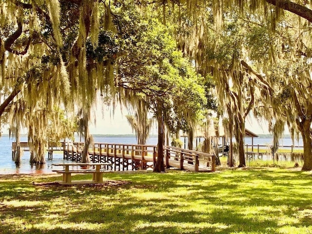 view of property's community featuring a water view and a lawn