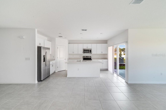 349 River Front Way, Edgewater, FL 32141 - kitchen with sink, white cabinetry, stainless steel appliances, a textured ceiling, and a center island with sink