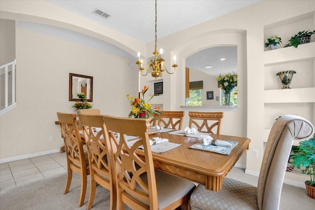 dining area featuring light tile patterned flooring, a notable chandelier, a textured ceiling, and built in features