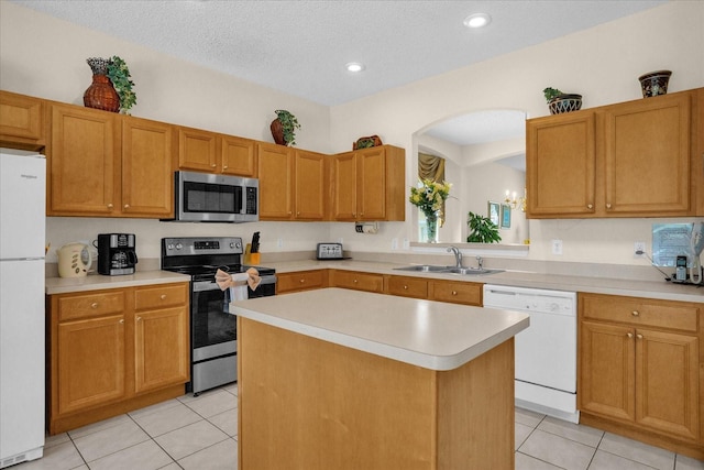 kitchen featuring sink, light tile patterned floors, appliances with stainless steel finishes, and a kitchen island