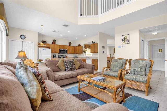 living room featuring light tile patterned flooring, sink, and a high ceiling