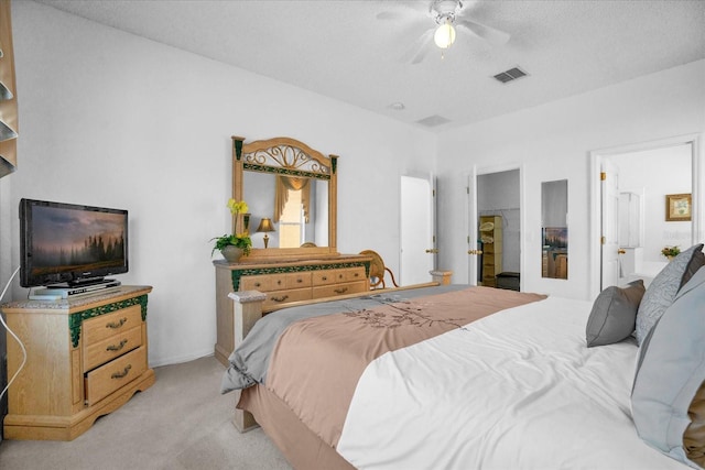 carpeted bedroom featuring ceiling fan, a textured ceiling, and ensuite bathroom