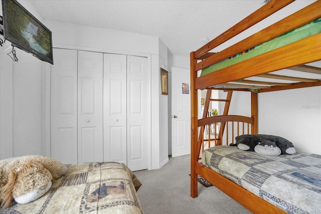 carpeted bedroom featuring a closet and a textured ceiling