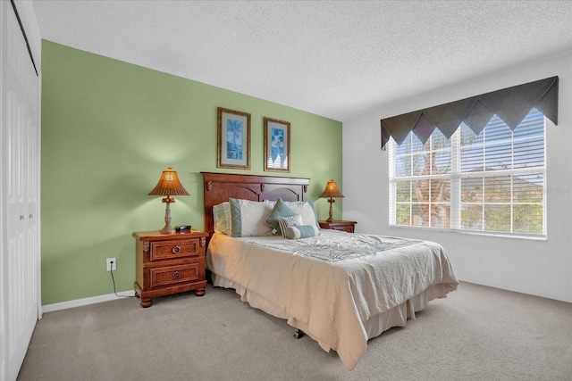 carpeted bedroom with a textured ceiling and a closet